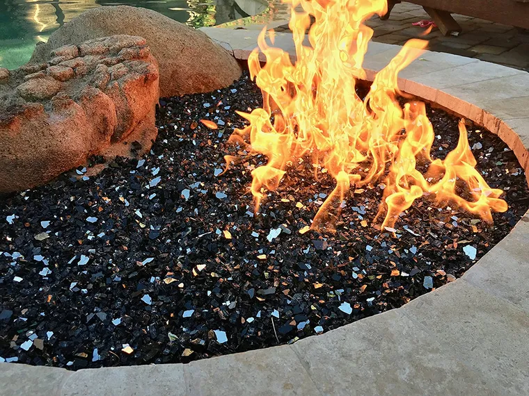Outdoor fireplace completed with black reflective fire glass
